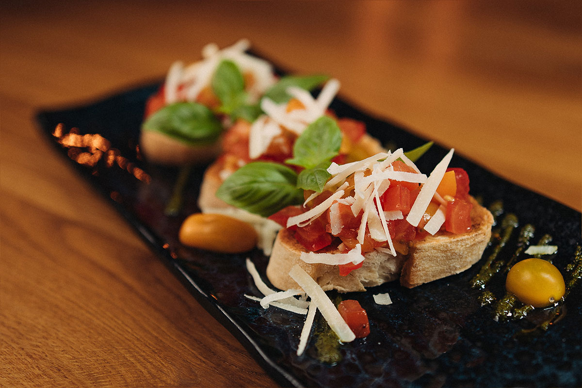 Bruschetta classic mit Tomatenwürfeln, Knoblauch, Olivenöl, frischem Basilikum und Parmegiano